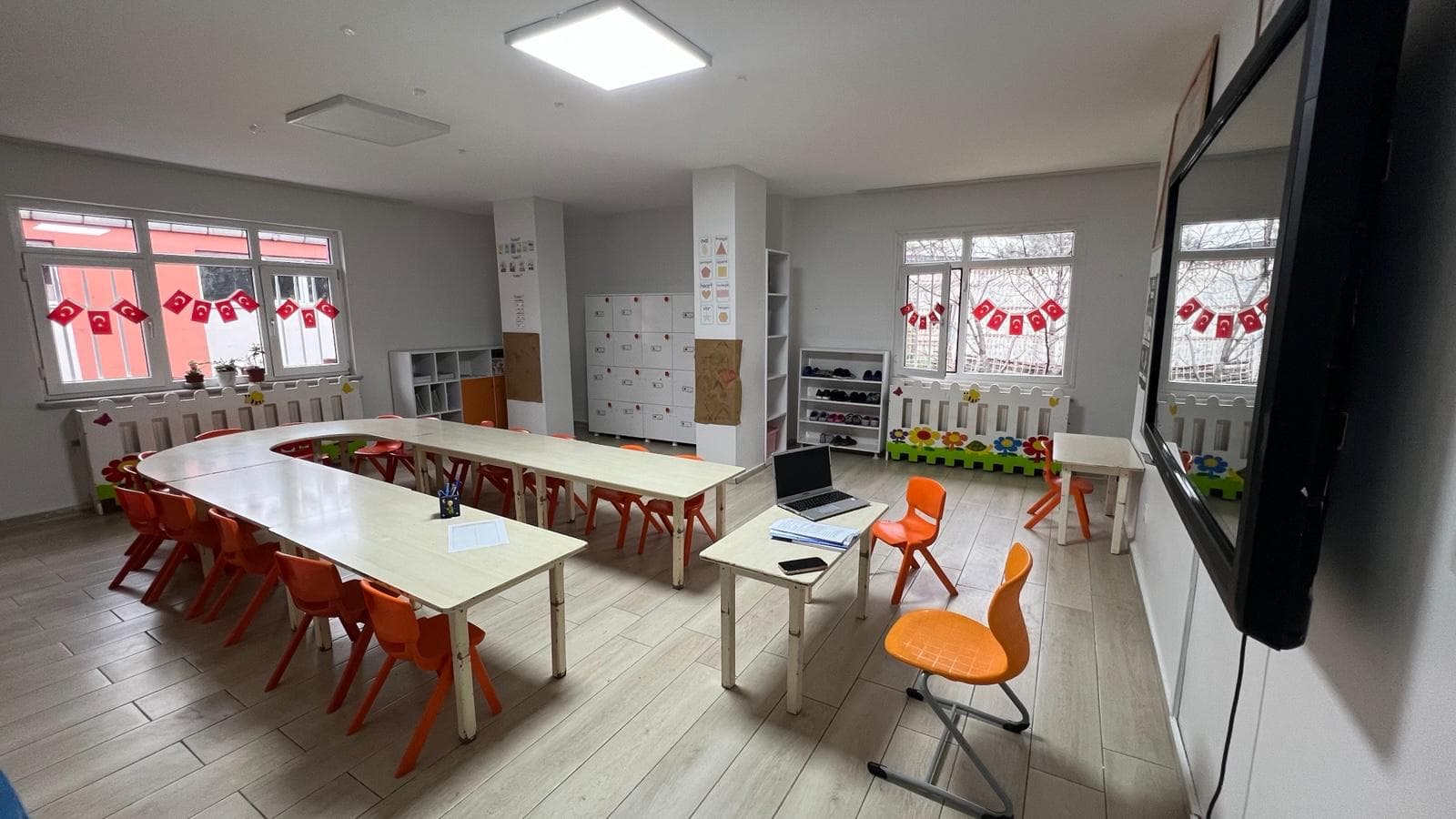 Anaokulu etkinlik sınıfı — U düzeninde masalar ve akıllı tahta